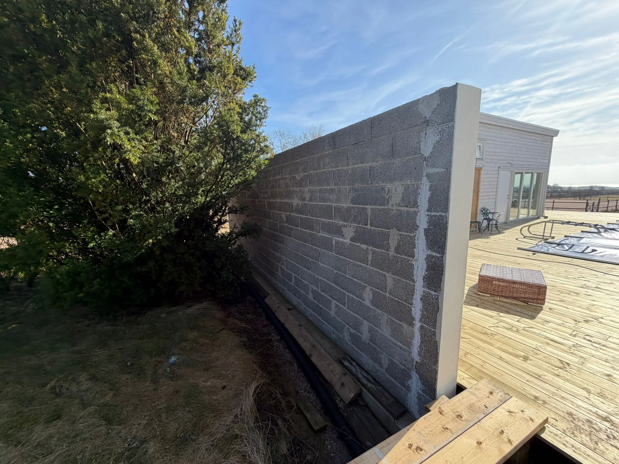 Cementblocksmur under uppbyggnad vid markarbete i Båstad
