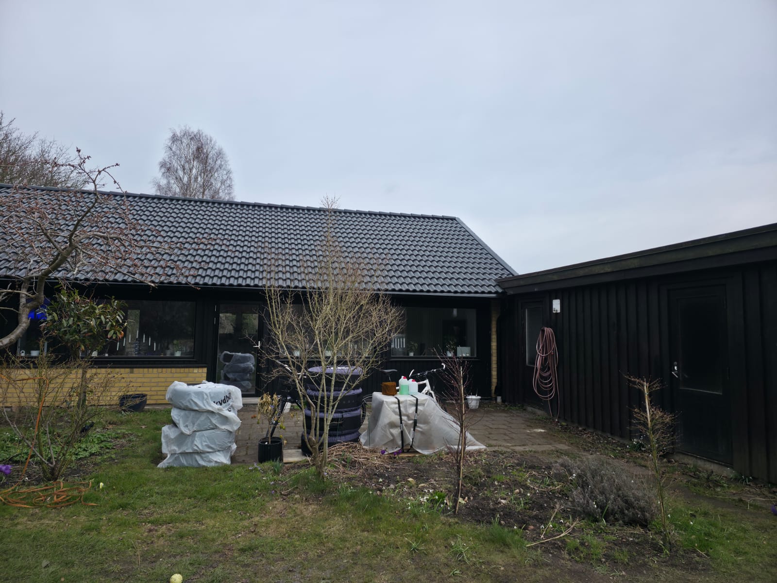 Villa i Lund med gul tegelgrund och ny svart träfasad efter renovering