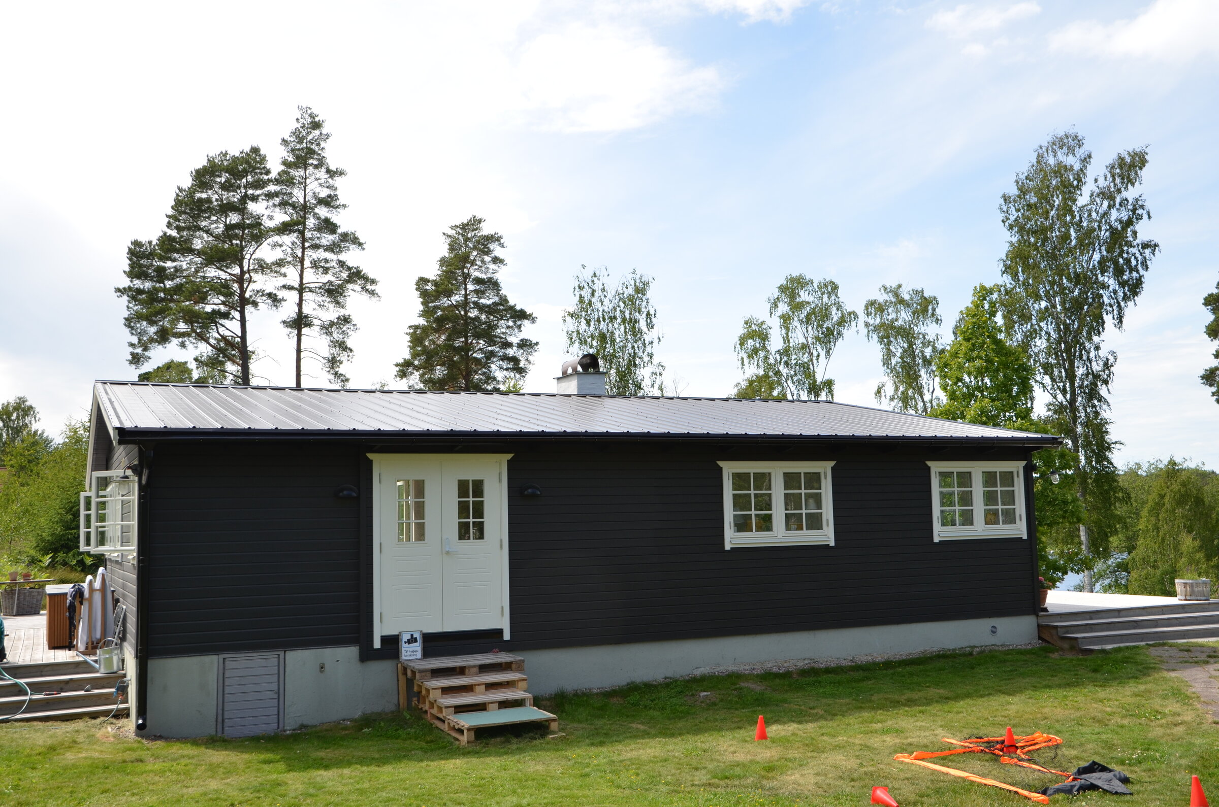 Svart hus med mörkt pannplåtstak, monterat av Arbetslag Bygg