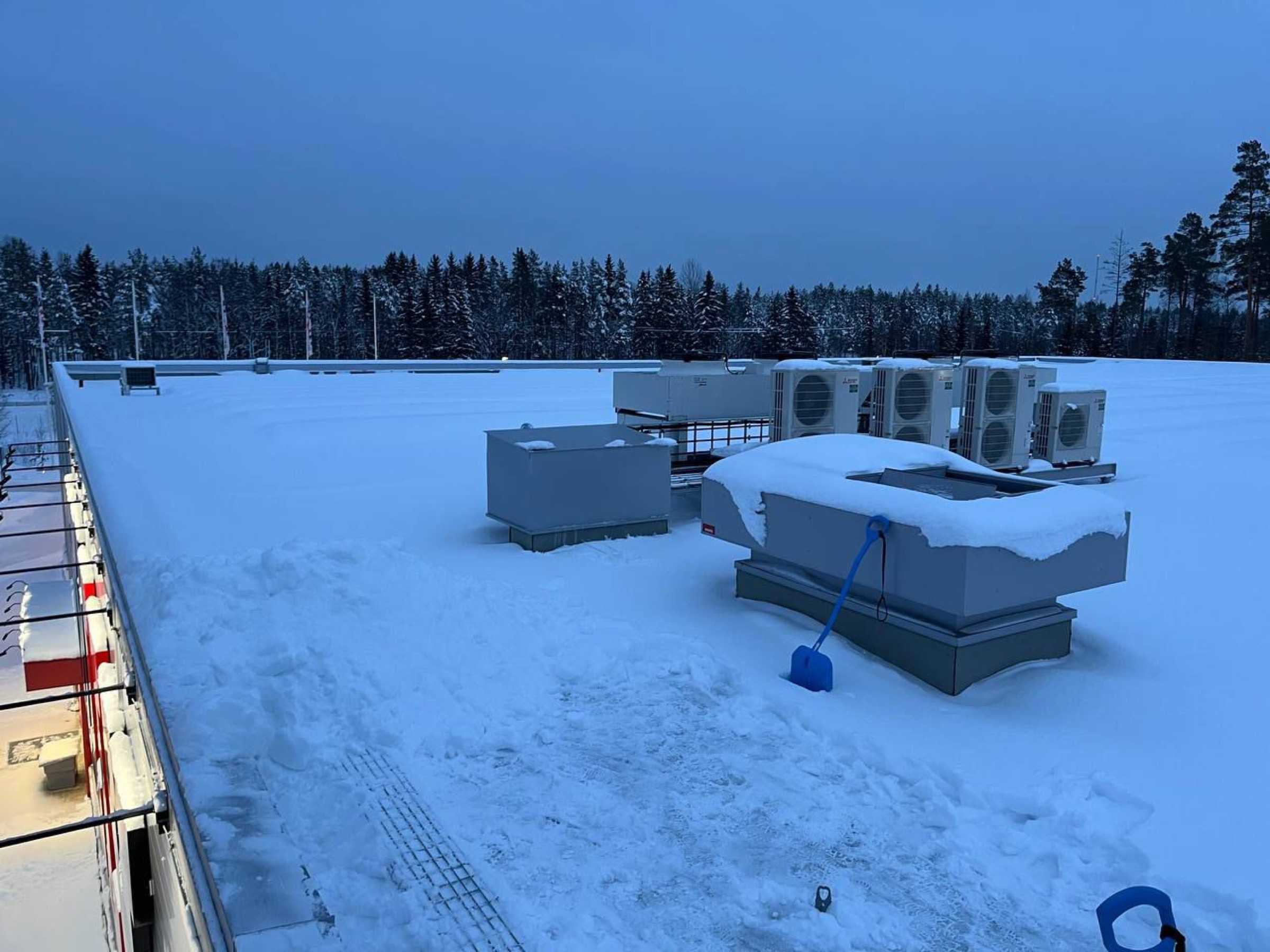 Snöskottat platt tak med ventilationsaggregat i skymning, av Arbetslag