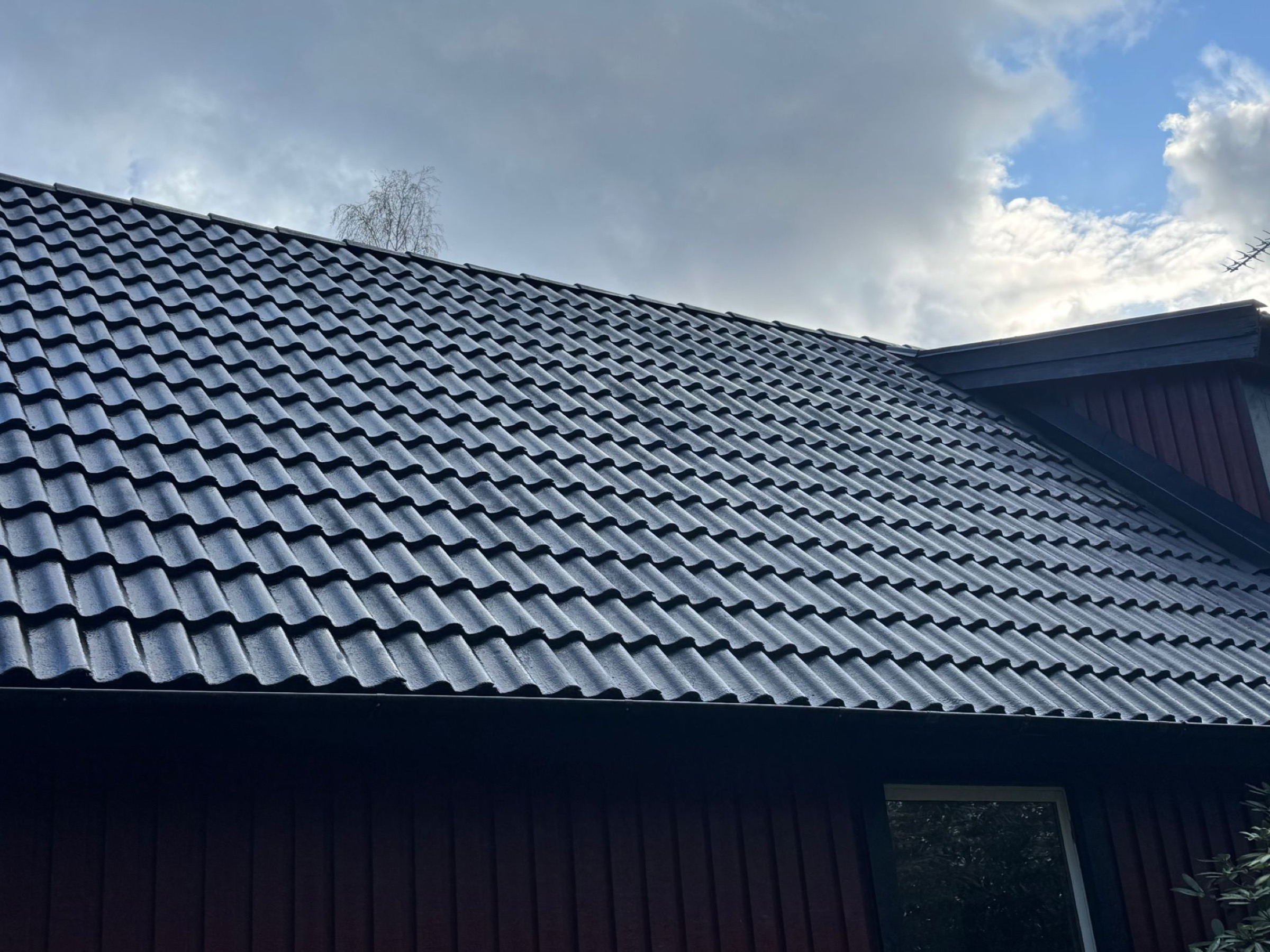 Närbild på mörkt tegeltak i gott skick, underhållet av Arbetslag Bygg